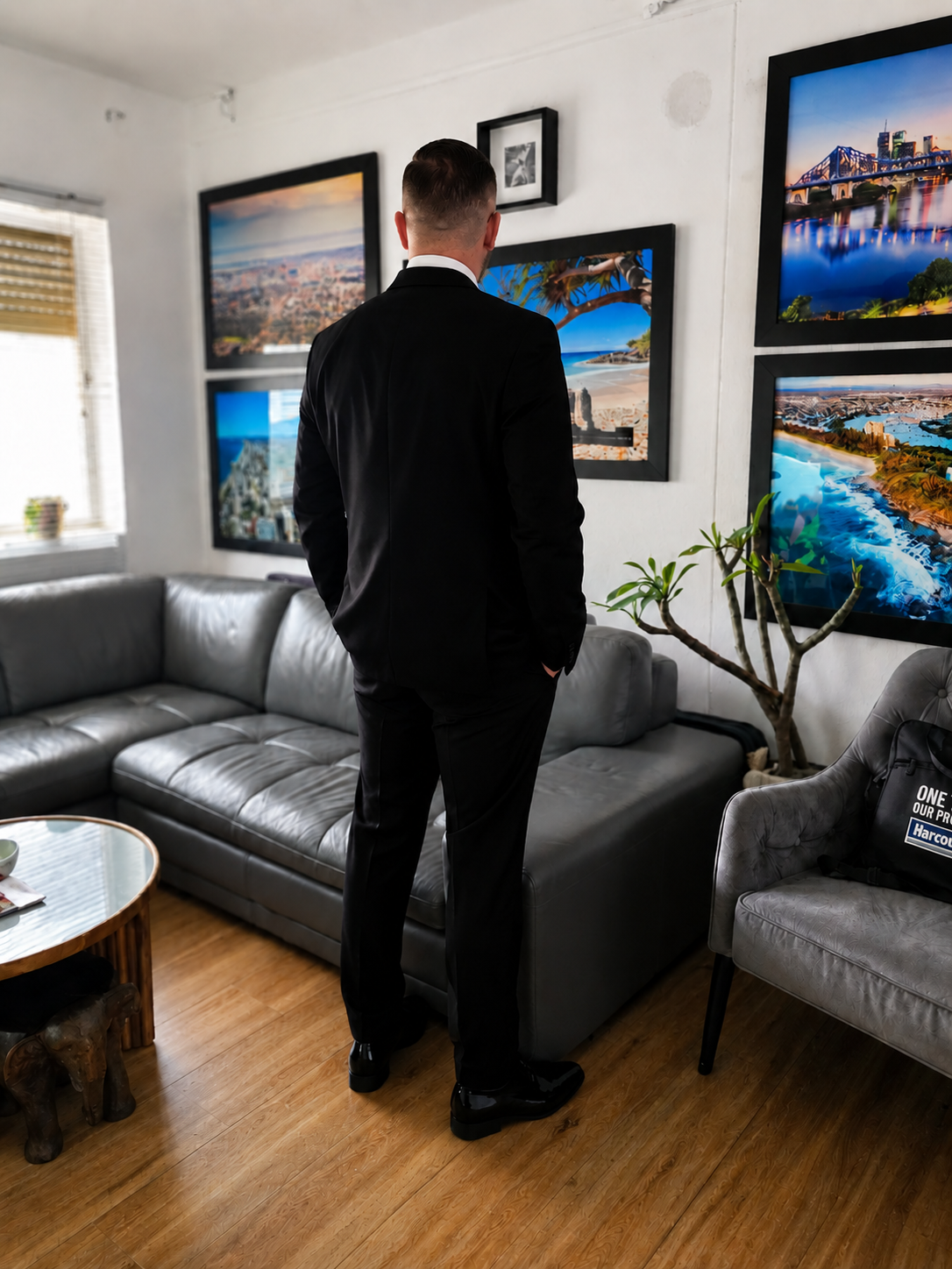 Nico Moretti standing in a tailored black suit, viewed from behind, commanding presence.